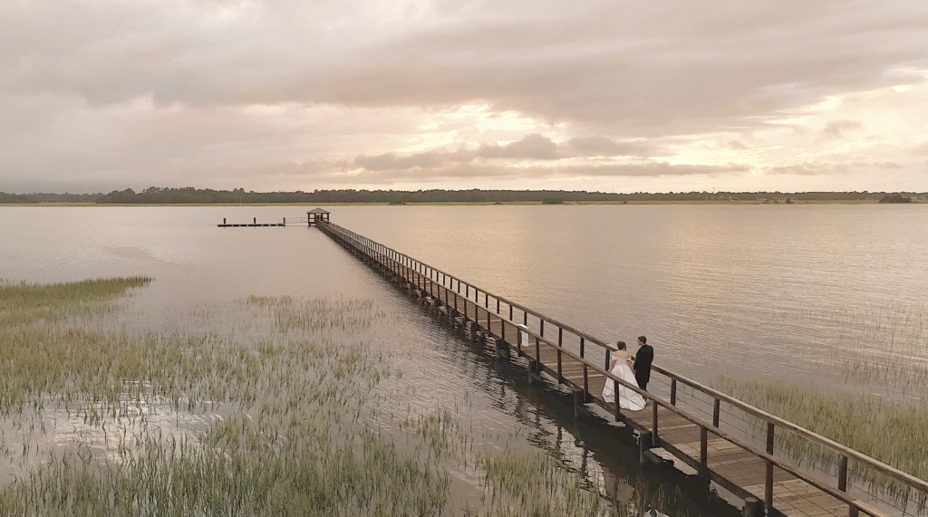 Happy couple walks down the River Dock at Lowndes Grove during sunset. 